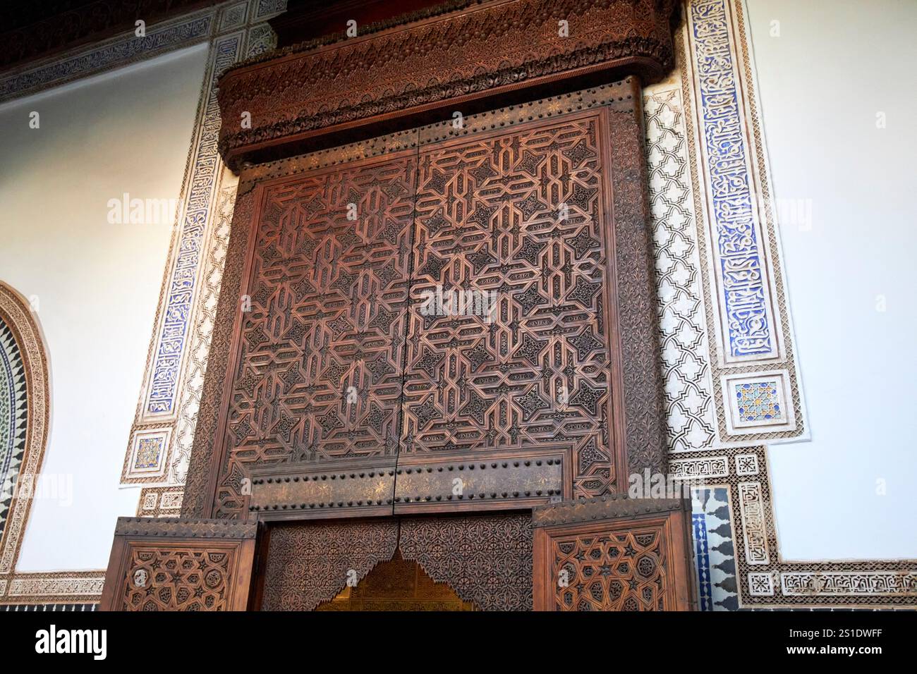 camera interna decorata con piastrelle e porta in legno intagliato, il museo dar el bacha di marrakech, marocco Foto Stock