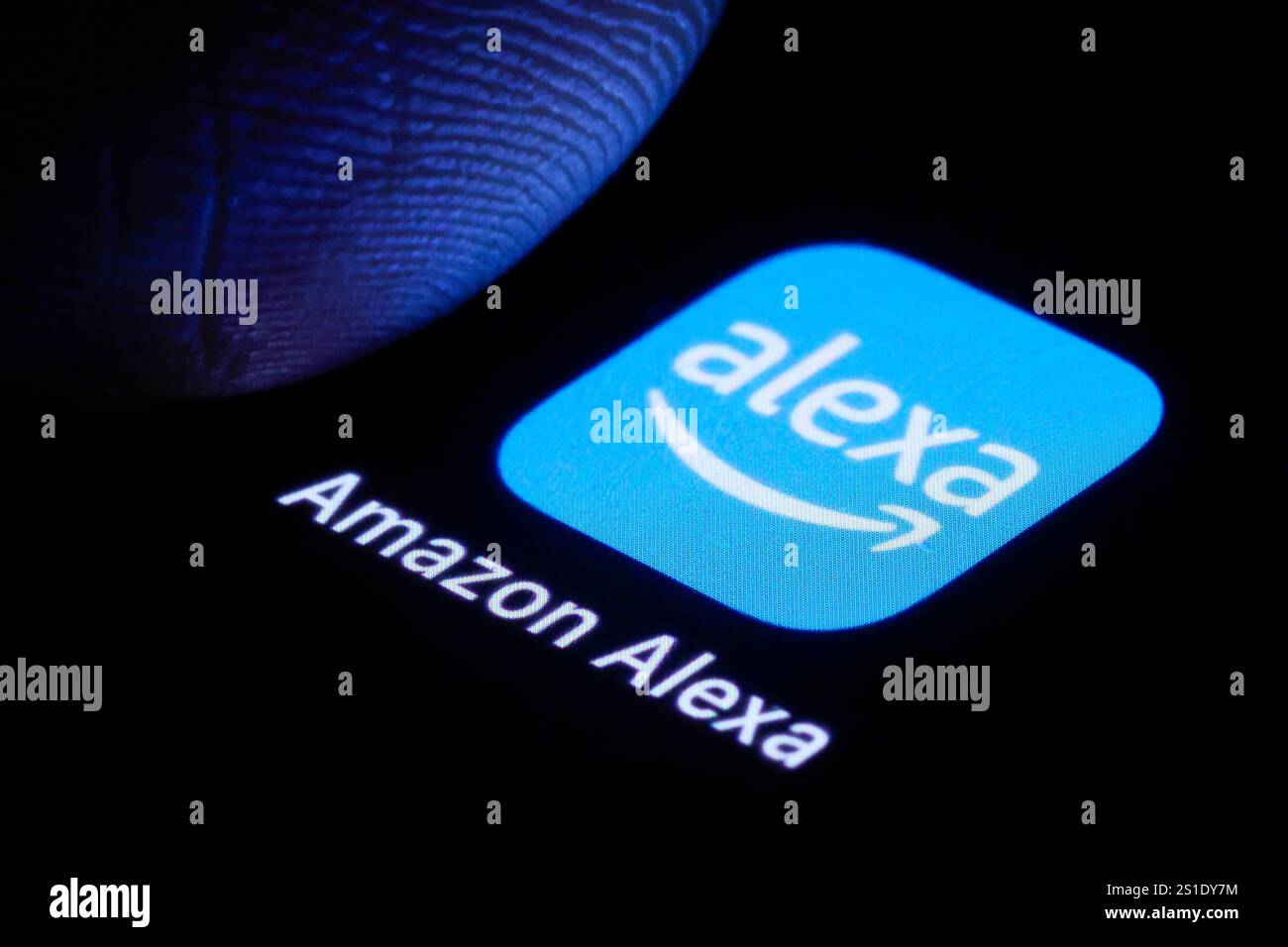 Logo DAS der Amazon Alexa App ist neben einem Finger auf einem smartphone zu sehen. Berlino, 03.01.2025. Berlin Deutschland *** il logo dell'Amazzonia Foto Stock