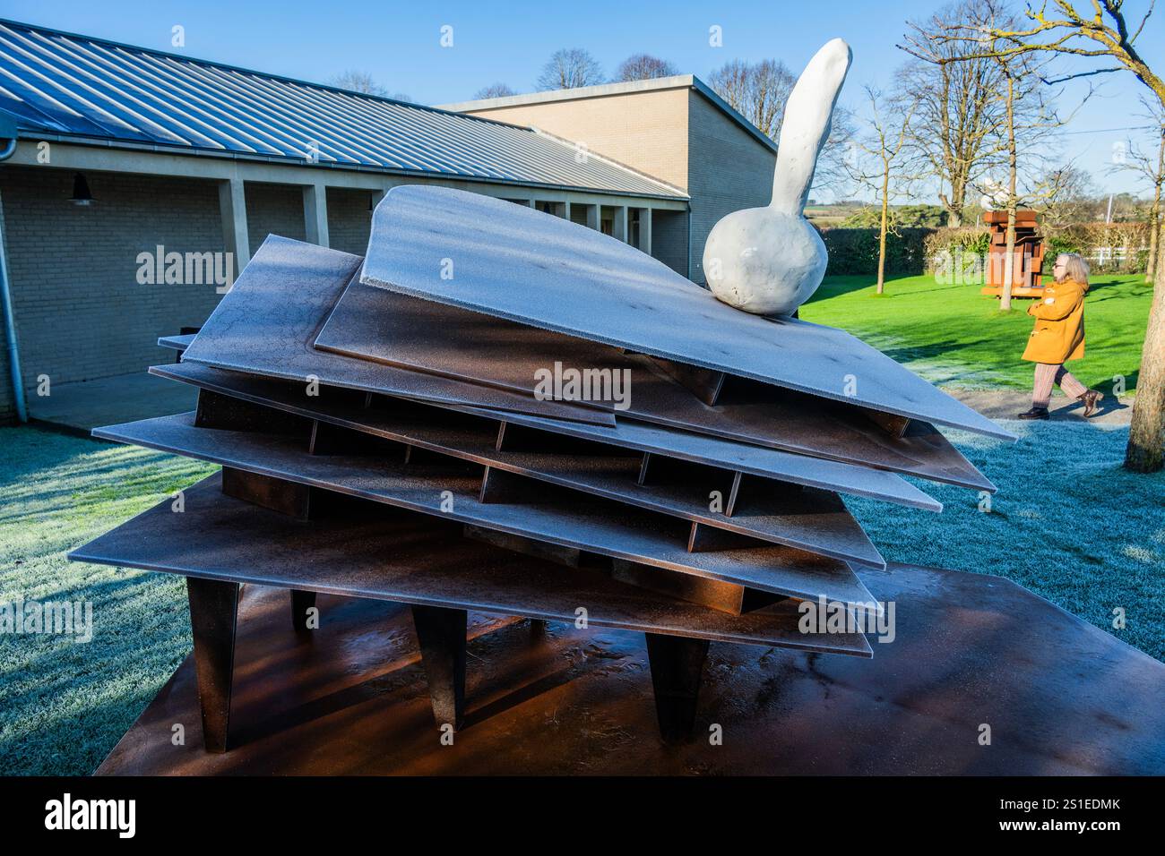 Le persone apprezzano il clima fresco nell'area del parco delle sculture, che include opere della serie PRANK (incl bufala), 2022/3. Il lavoro di Phyllida Barlow (1944 - 2023) prende il controllo di Hauser & Wirth Somerset in una celebrazione dell'approccio trasformativo dell'artista britannico alla scultura; in occasione del decimo anniversario della galleria. A cura di Frances Morris, «Phyllida Barlow. UnScripted' riunisce una collezione di elementi distintivi dell'artista provenienti da diverse importanti installazioni, nonché una serie di sculture indipendenti che vanno dai primi anni '1970 al lavoro realizzato nell'ultimo anno di vita di Barlow. CR Foto Stock