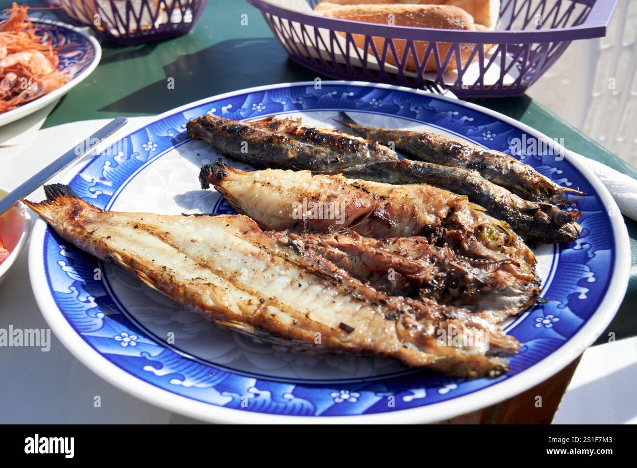 pesce fresco, tra cui orata e sardine, servito nel ristorante collettivo di pescatori nel porto di essaouira, in marocco Foto Stock