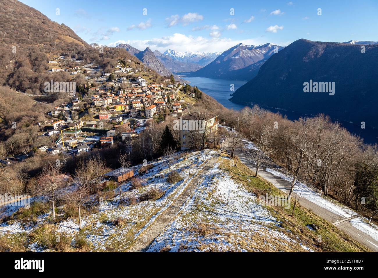 Vista dal Monte Bre del paese, del lago di Lugano, delle montagne circostanti e della neve sparsa, Svizzera Foto Stock