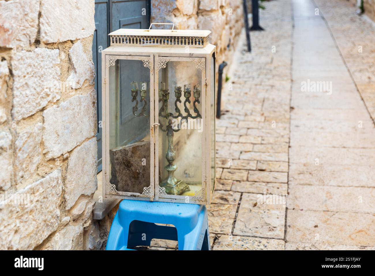 Menorah Hanukkah in un armadietto di vetro durante le celebrazioni di Hanukkah sulla strada della città vecchia di Tzfat, in Israele. Foto Stock