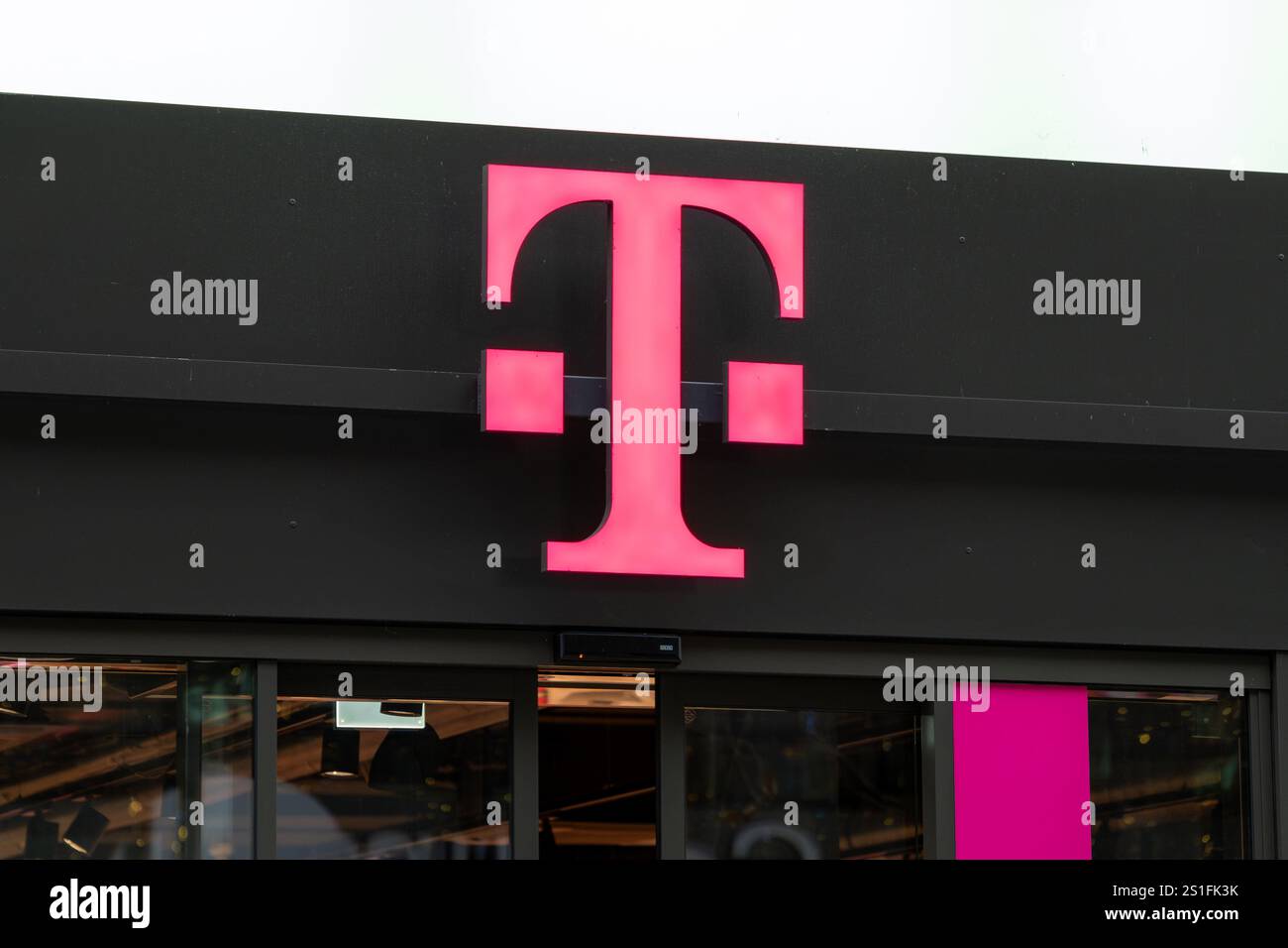 Insegna con il logo Telekom Shop sulla facciata. La lettera T color magenta è l'icona delle società Deutsche Telekom e T-Mobile. Foto Stock