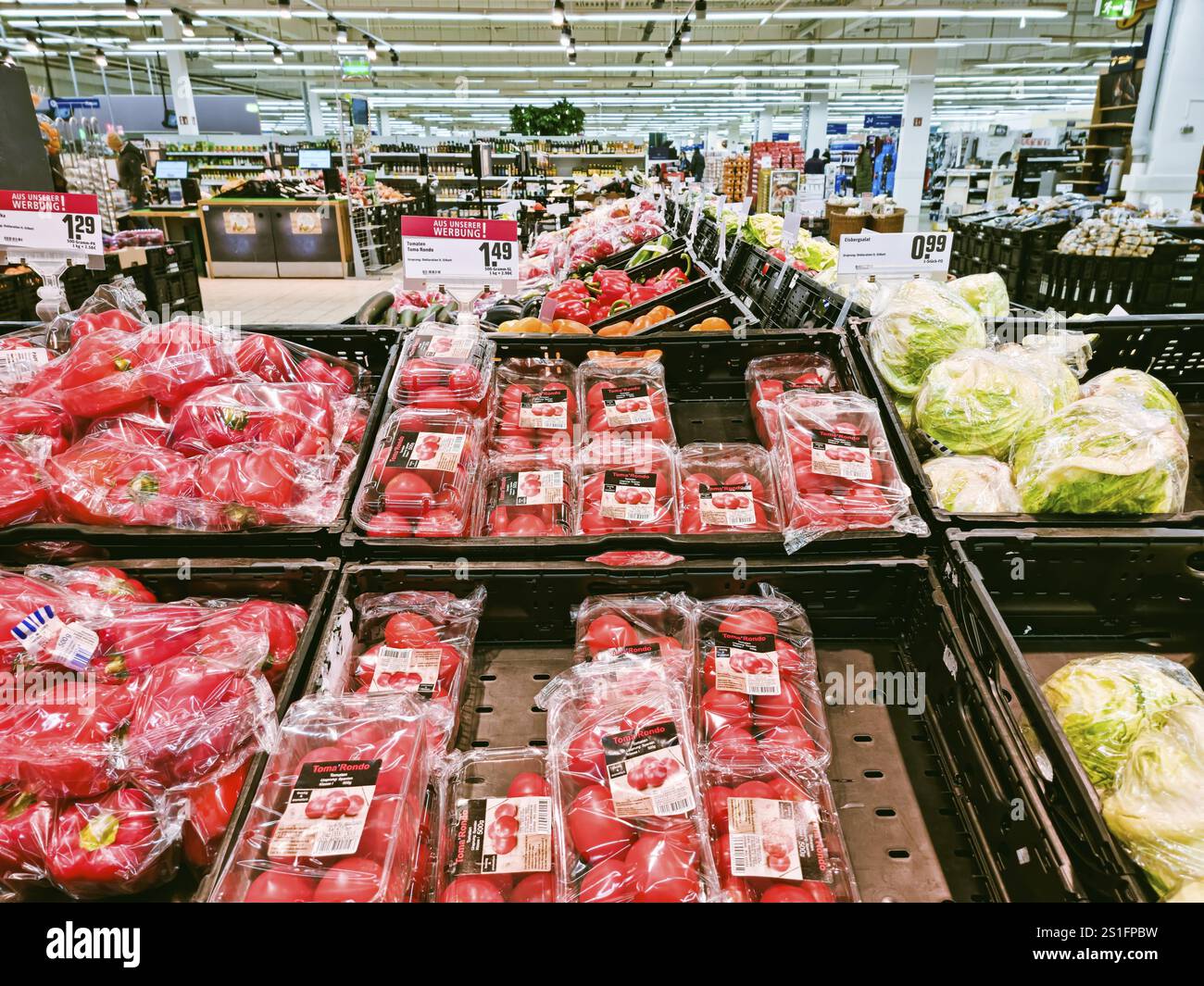 WETZLAR, ASSIA, Deutschland 12-21-2022: Pomodori freschi e succosi, paprica e lattuga confezionati su un tavolo di vendita in un negozio di alimentari Foto Stock