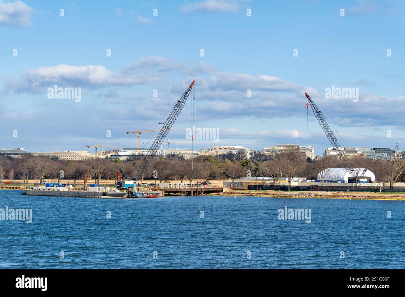 WASHINGTON DC, Stati Uniti - in questa foto scattata il 2 gennaio 2025, gli equipaggi di costruzione lavorano per ricostruire le storiche banchine lungo il bacino di marea a Washington DC. Il progetto infrastrutturale da 500 milioni di dollari riabiliterà circa 6.800 metri lineari di diga deteriorata che si è insediata fino a cinque metri dalla sua costruzione originale. Il progetto di restauro, finanziato attraverso il Great American Outdoors Act, mira a proteggere gli iconici alberi di ciliegio del bacino delle maree e a prepararsi per il 250° anniversario della nazione nel 2026. Foto Stock