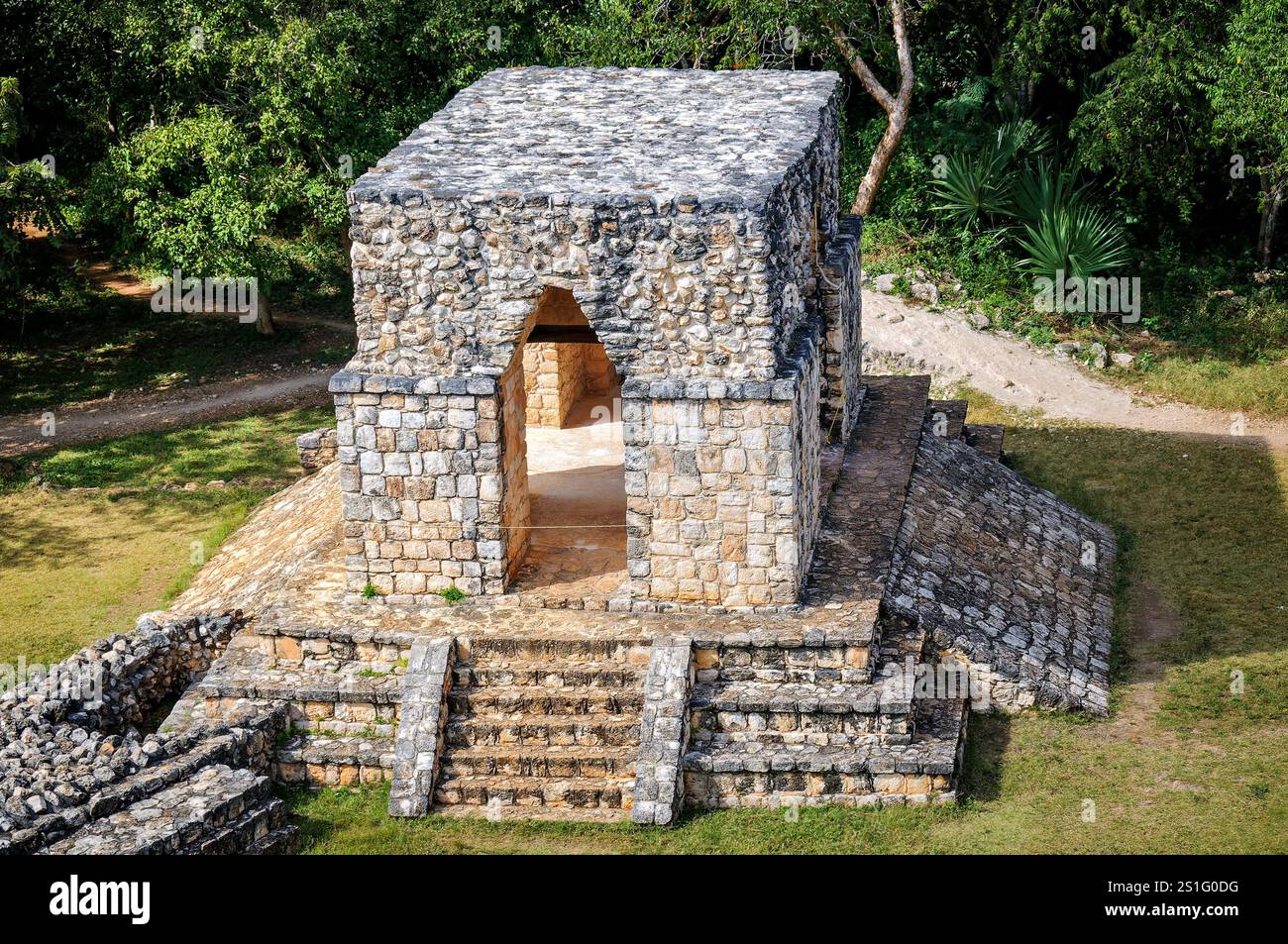 Ekʼ Balam Entrance Arch Maya Site Yucatan Messico // EKʼ BALAM, Messico — l'Arco di entrata è uno degli ingressi formali al sito archeologico di Ekʼ Balam. Questa struttura calcarea dimostra le tecniche di costruzione della volta a mensola Maya tipiche del tardo periodo classico (600-900 CE). L'arco rappresenta elementi caratteristici dell'architettura civica Maya e della pianificazione urbana da quando Ekʼ Balam servì come capitale del regno di Talol. Ekʼ Balam raggiunse il suo apice tra il 770-840 d.C. sotto il re Ukit Kan le'k Tok', diventando uno dei centri maya più significativi del northe Foto Stock
