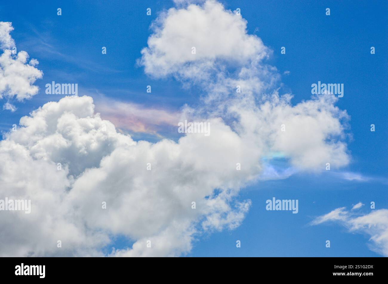 colori simili all'arcobaleno che sbirciano tra le nuvole di metà pomeriggio Foto Stock
