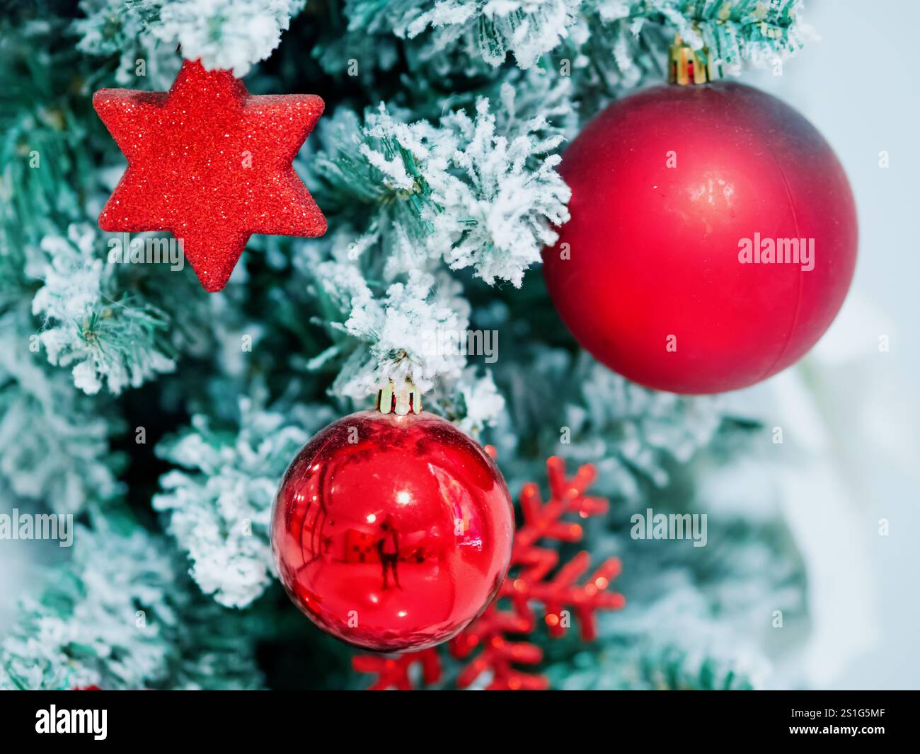 Decorazioni dell'albero di Natale sui rami dell'albero di Natale. Decorazioni in forma di sfere rosse e stella esagonale sull'albero di Natale decorativo. Celebratina Foto Stock