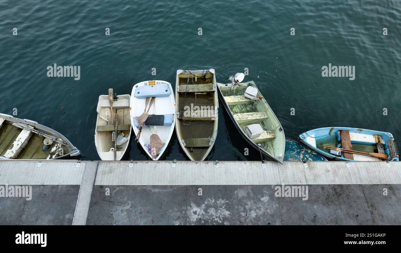 Barche a remi ormeggiate piene d'acqua piovana dopo un temporale vicino al porticciolo sul lungomare di Monterey, California, e alle banchine, prendendo l'acqua da una tempesta. Foto Stock
