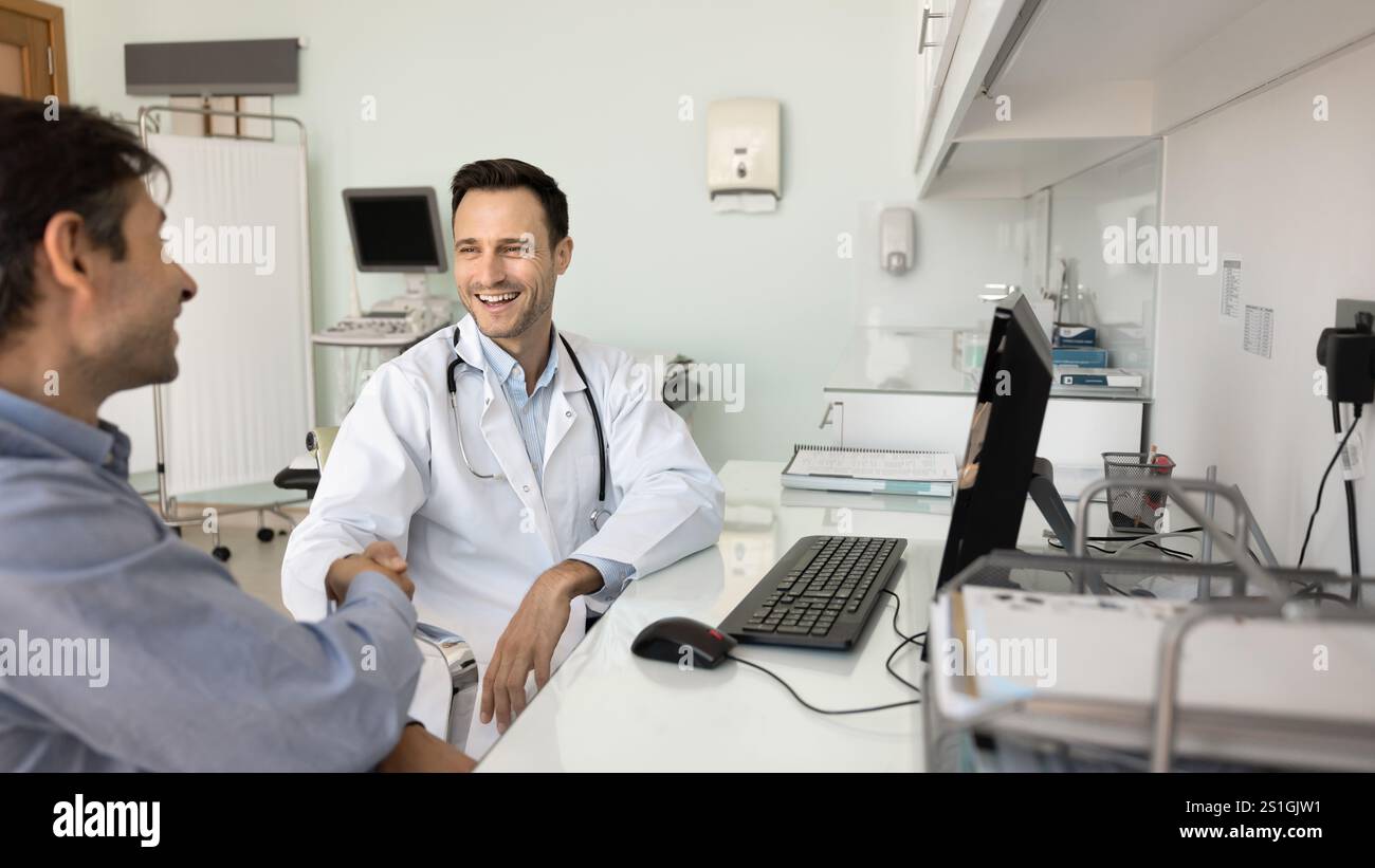 Medico ecografo felice che stringe la mano a un paziente di sesso maschile Foto Stock