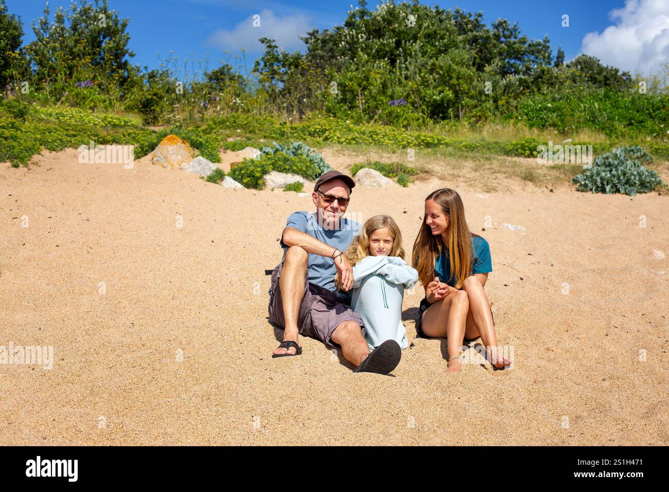 Una famiglia di tre persone seduta su una spiaggia a Isles of Scilly, cornovaglia Foto Stock Una famiglia di tre persone seduta su una spiaggia a Isles of Scilly, cornovaglia Foto Stock