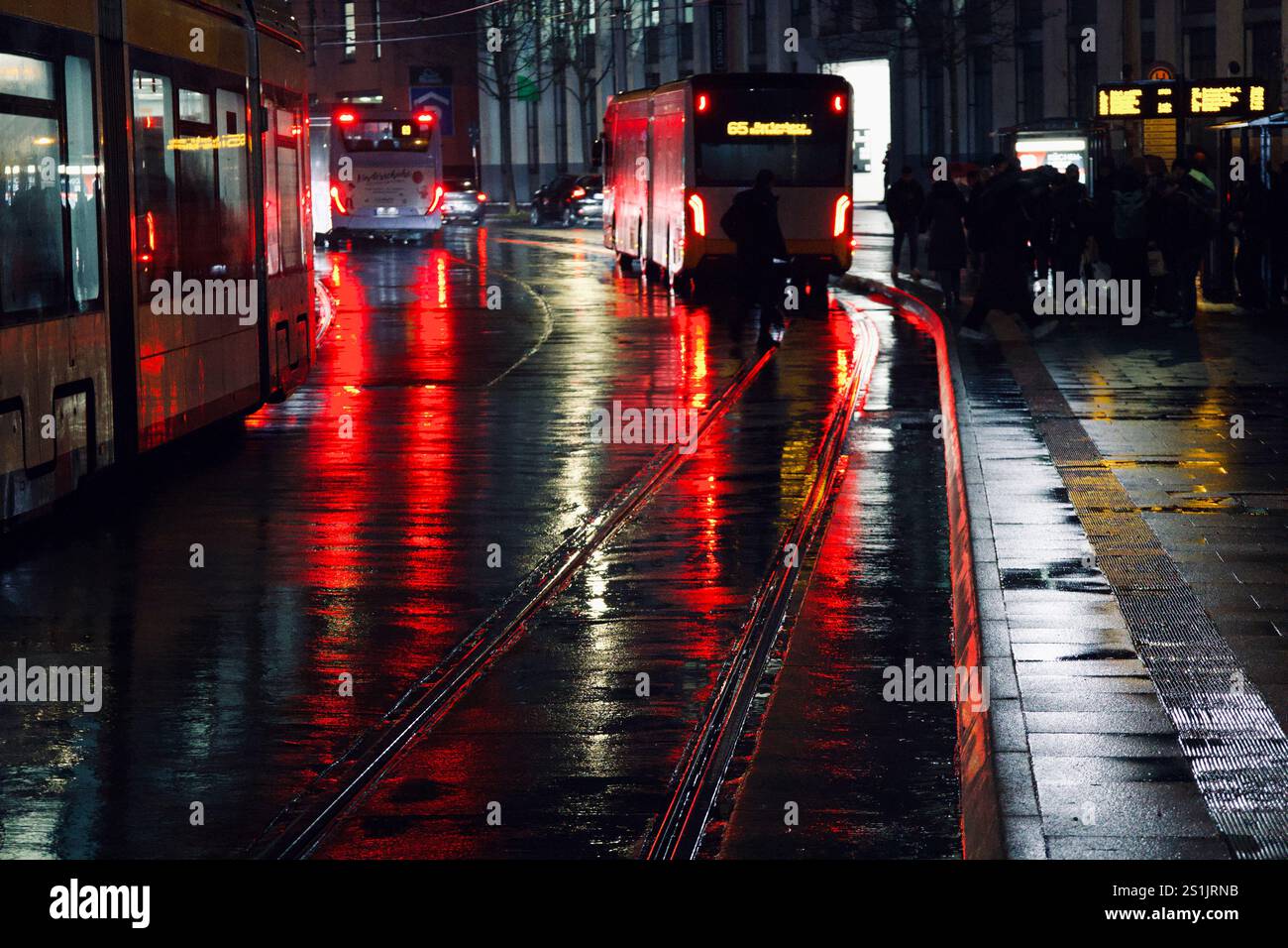 Mainz, Germania. 5 dicembre 2024. Un autobus su una strada bagnata illuminato. Foto Stock