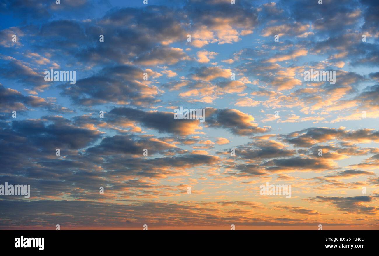 Bellissime nuvole colorate e soffici e la calda alba risplendono sul cielo blu Foto Stock