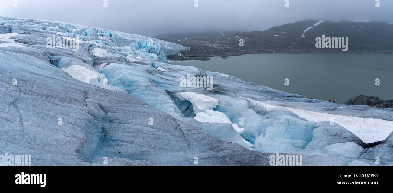 Vista panoramica del ghiacciaio Austdalsbreen e del lago Styggevatnet a Jostedal, Norvegia, in una giornata nuvolosa, che mostra ghiaccio intatto con grandi crepe, senza picchio Foto Stock