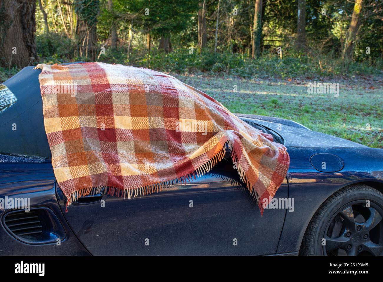 Auto coperta da una coperta colorata per evitare la formazione di ghiaccio durante la notte sul parabrezza anteriore e sul finestrino del conducente, Regno Unito Foto Stock