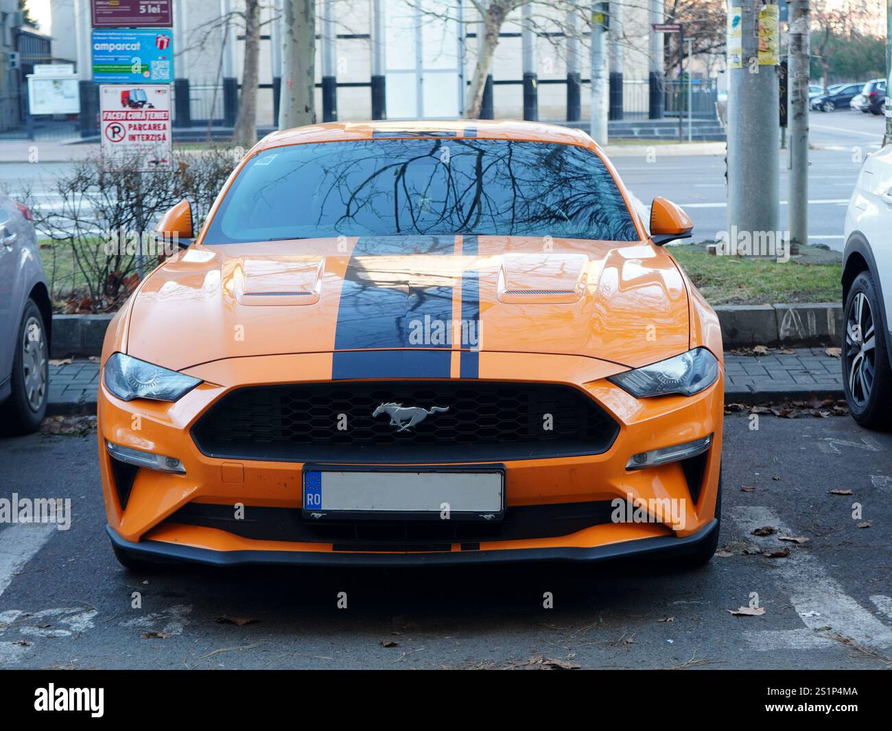 Bucarest, Romania - 1 gennaio 2025: Vista frontale dell'auto gialla Ford Mustang parcheggiata in città Foto Stock