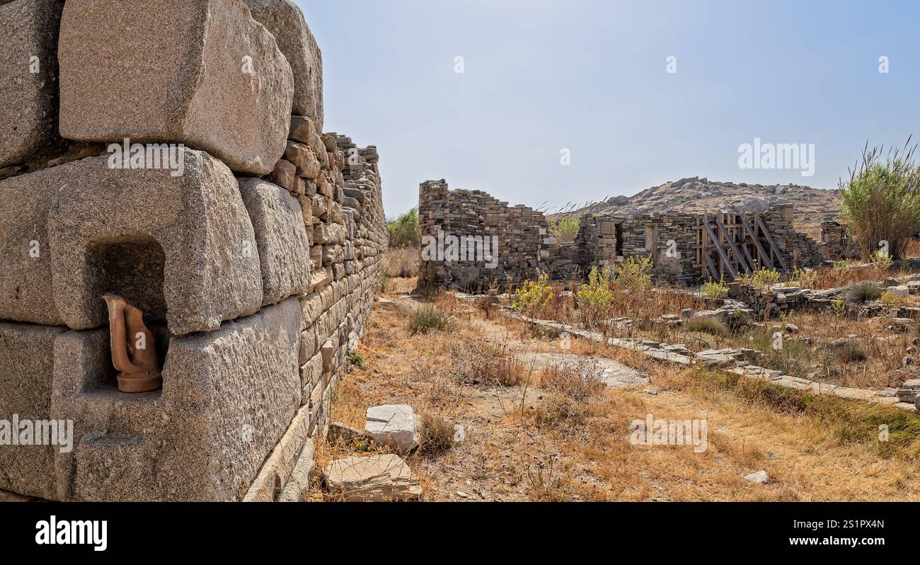 Antiche rovine di pietra sotto un cielo azzurro in un paesaggio asciutto, Delo, Grecia Foto Stock
