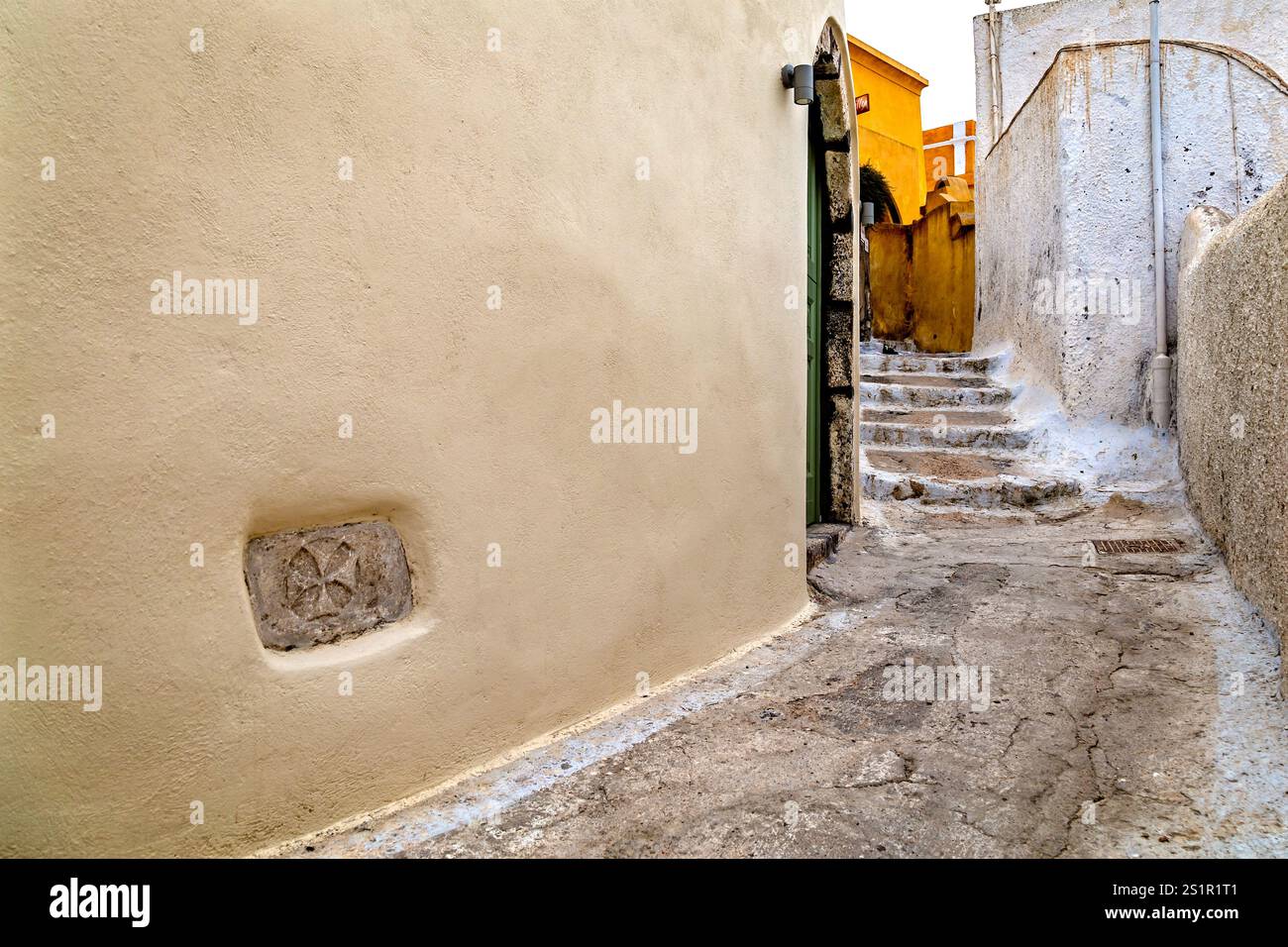 Affascinante vicolo stretto con scale in pietra rustica nel villaggio storico di Santorini, Grecia Foto Stock