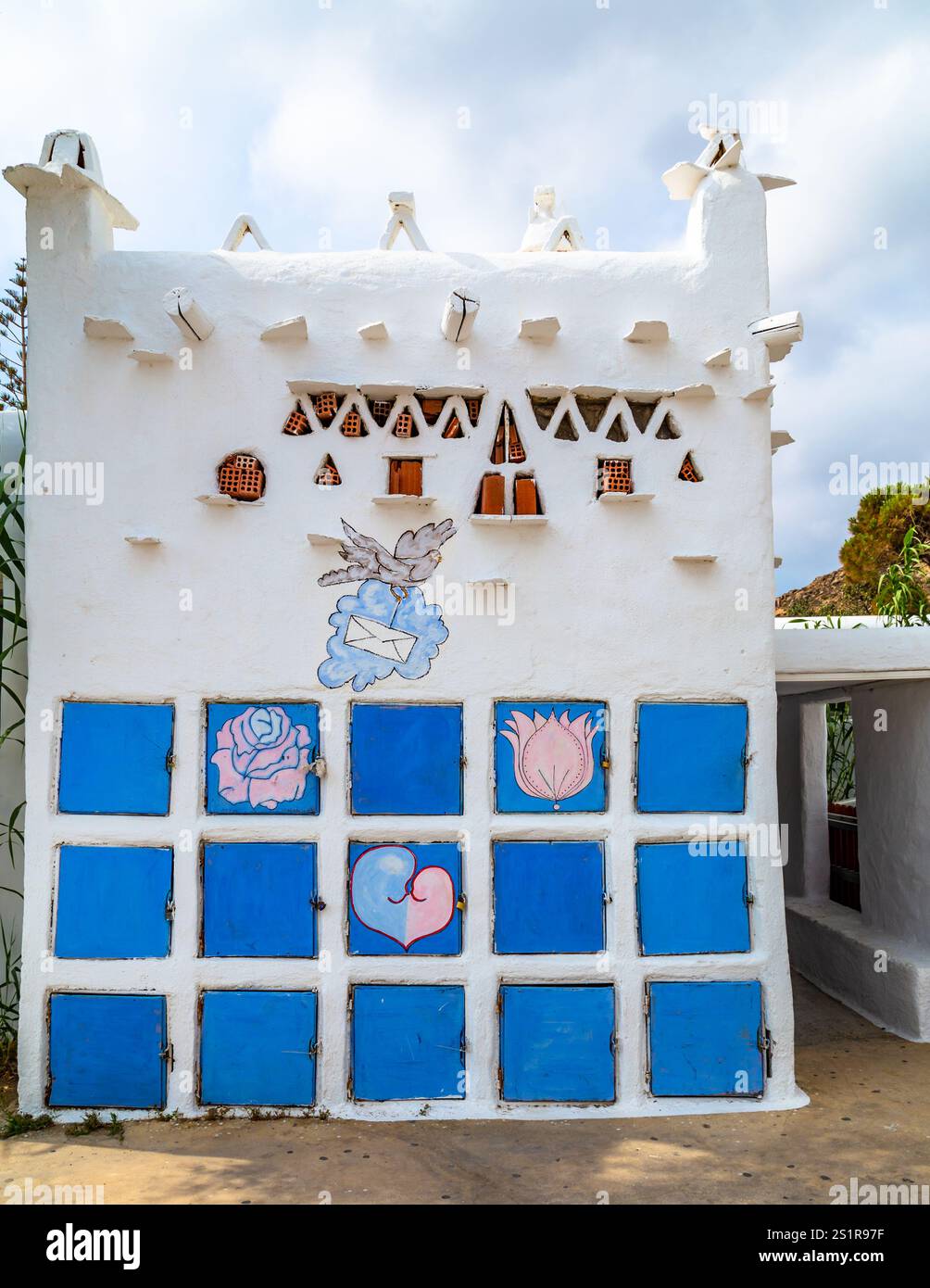 Edificio decorativo con persiane blu e motivi artistici dipinti in un ambiente soleggiato, Paradise Beach, Mykonos, Grecia Foto Stock