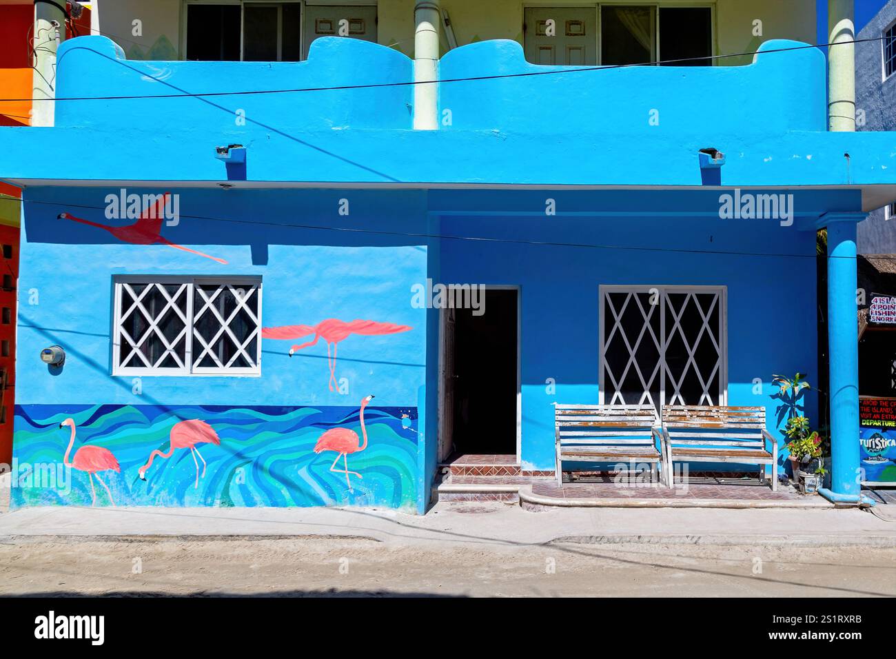 Edificio Vivid Blue con pareti in stile Flamingo e panchine all'aperto, Isla Holbox, Messico Foto Stock