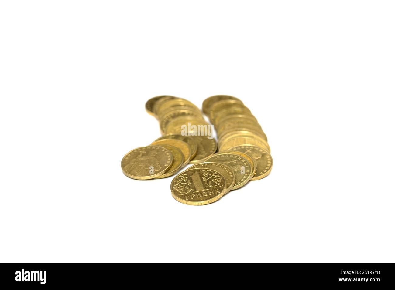 Una varietà di monete d'oro sono impilate ordinatamente su una superficie bianca all'interno di una stanza ben illuminata. Le monete riflettono la luce, mostrando i loro intricati disegni e. Foto Stock