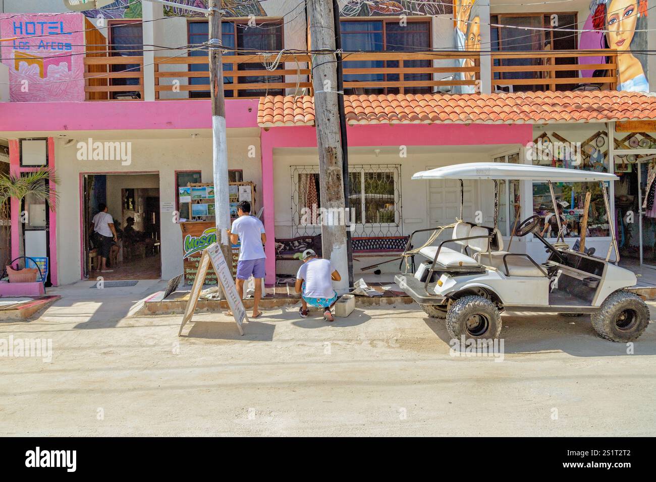 Colorata strada con golf cart ed edifici vivaci, Isla Holbox, Messico Foto Stock