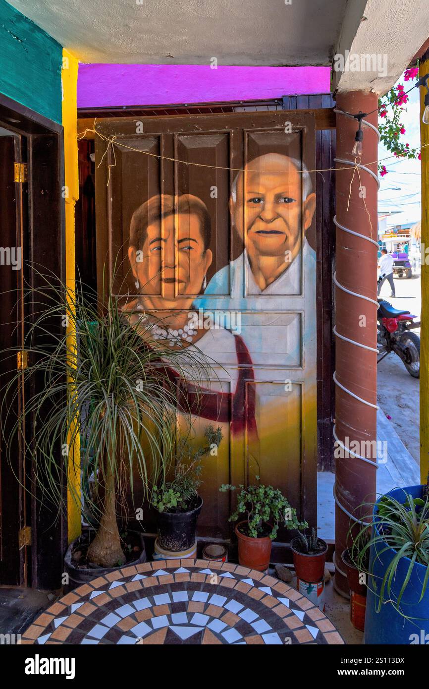 Ingresso colorato con ritratti culturali dipinti in un vivace ambiente urbano, Isla Holbox, Messico Foto Stock