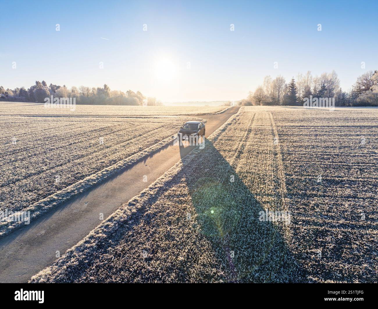 Un SUV guida lungo una strada di campagna ghiacciata alla luce del mattino d'inverno, Car Sharing, auto elettrica, Volkswagen ID 5, Gechingen, regione di Hecken und Gaeu, Foto Stock