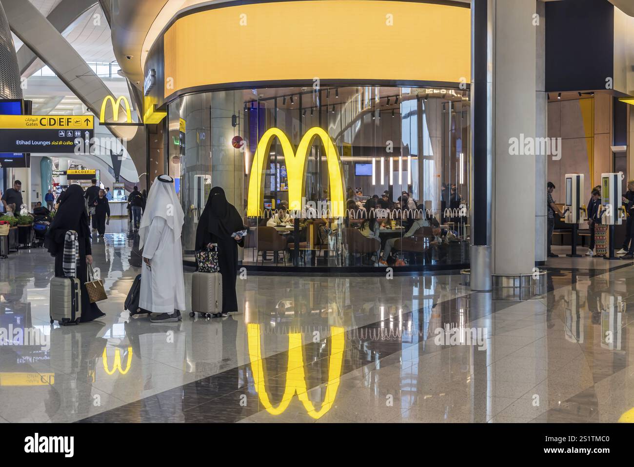Aeroporto di Abu Dhabi, aeroporto internazionale di Zayed con passeggeri. Ristorante McDonalds. Il nuovo Terminal A ha una capacità di 45 milioni di passeggeri per anno Foto Stock