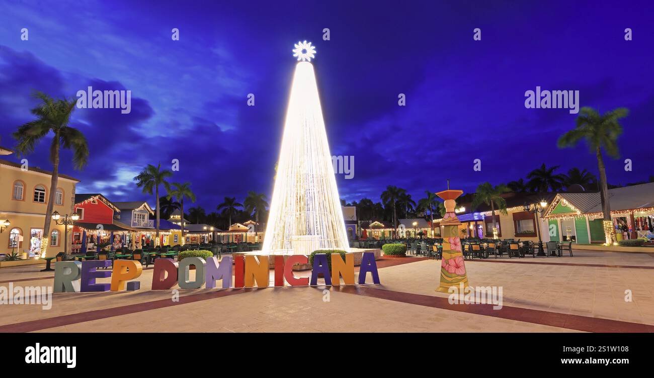 Splendido albero di Natale illuminato, cartello della Repubblica Dominicana e piazza del centro commerciale al crepuscolo a Punta Cana Foto Stock