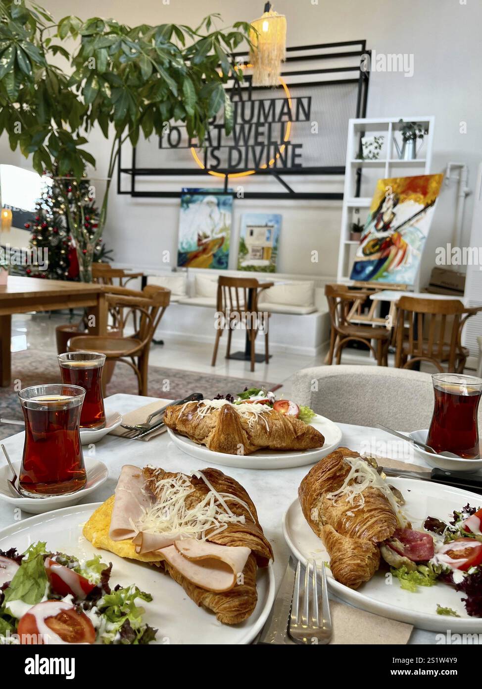 Sala da pranzo decorativa con croissant per la colazione e tè sul tavolo, sdgf Foto Stock