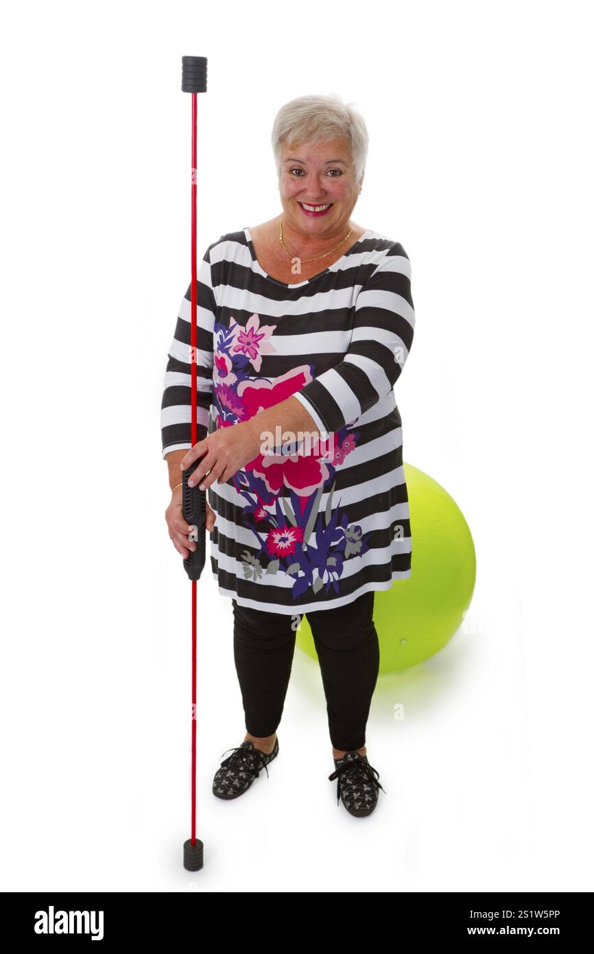 Donna anziana con bastone oscillante e palla da ginnastica - ritagliata su sfondo bianco Foto Stock