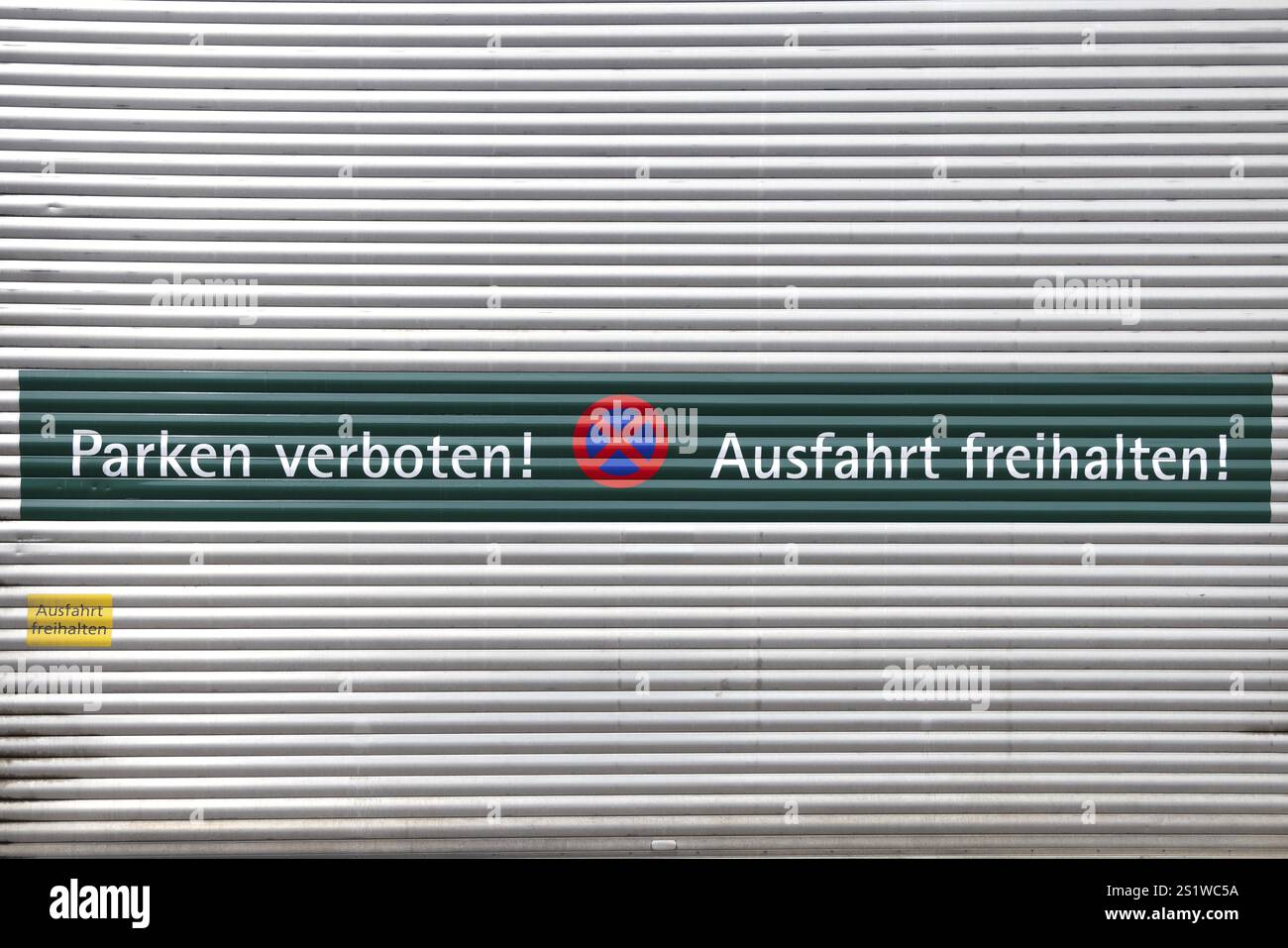 Rolltor mit der Aufschrift 'Parken verboten und Ausfahrt freihalten' auf Deutsch Foto Stock