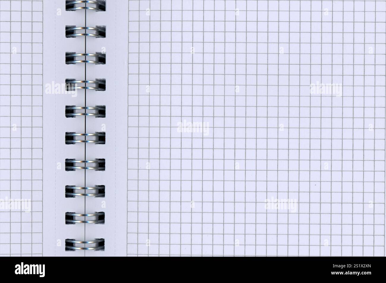 Dettaglio di un blocco a spirale aperto con carta a scacchi bianca Foto Stock