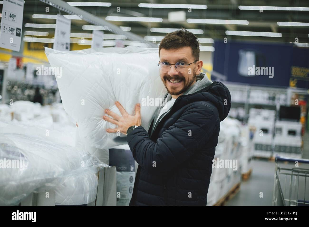 Un uomo sceglie un cuscino in un supermercato Foto Stock