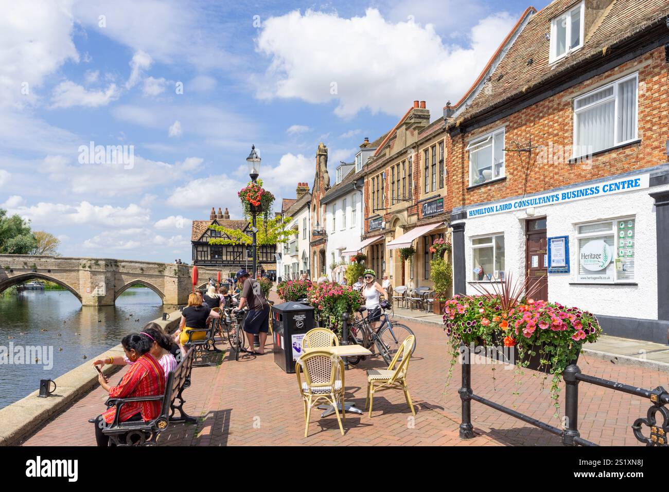 St Ives Quay - persone sedute vicino al fiume Great Ouse sul Quay a St Ives una città medievale mercato Cambridgeshire Inghilterra Regno Unito Europa Foto Stock