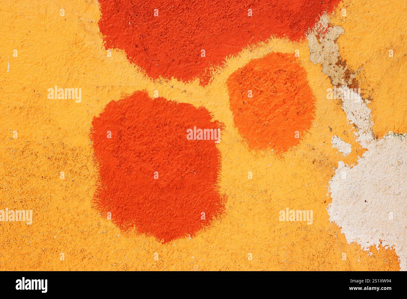 Struttura della vecchia casa in cemento dipinto in un profondo e vibrante colore giallo dorato con macchie arancioni e crepe sulla superficie. Intonaco decorativo. Foto Stock