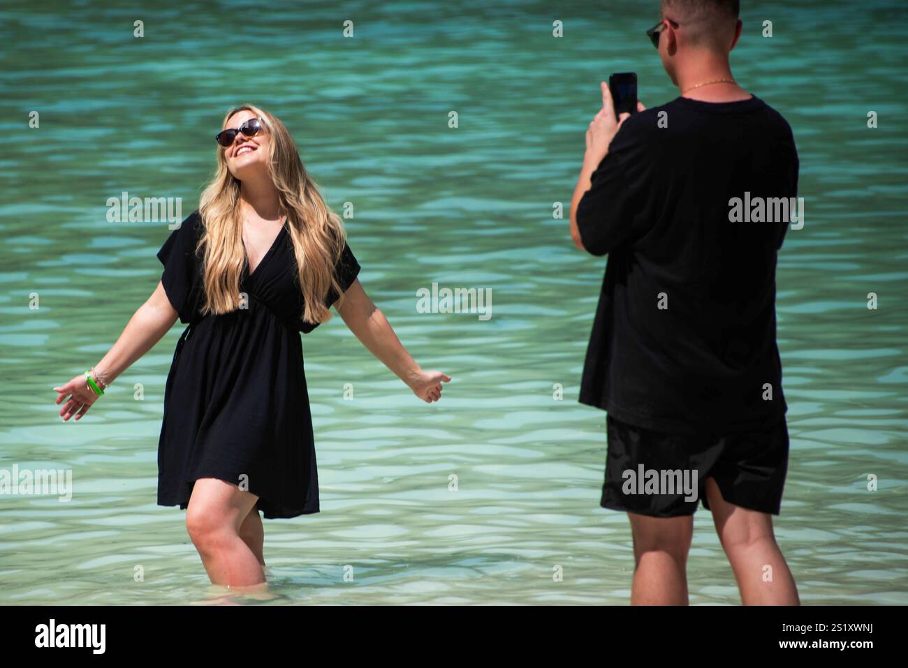 I turisti scaldano le iconiche acque turchesi di Maya Bay: Una vivace scena di selfie, pose e coste sovraffollate - "The Beach" con Leonardo DiCaprio Foto Stock