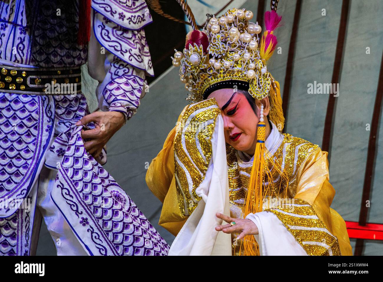 Artisti d'opera cinesi tradizionali che mostrano intricati costumi ed espressioni drammatiche durante le celebrazioni del capodanno cinese nel quartiere cinese di Chinatow di Bangkok Foto Stock
