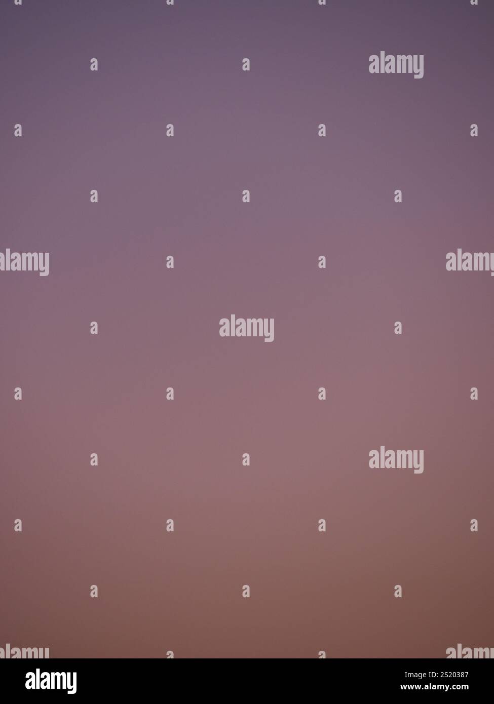 Sfumatura uniforme di viola chiaro e arancione in un cielo chiaro al crepuscolo Foto Stock