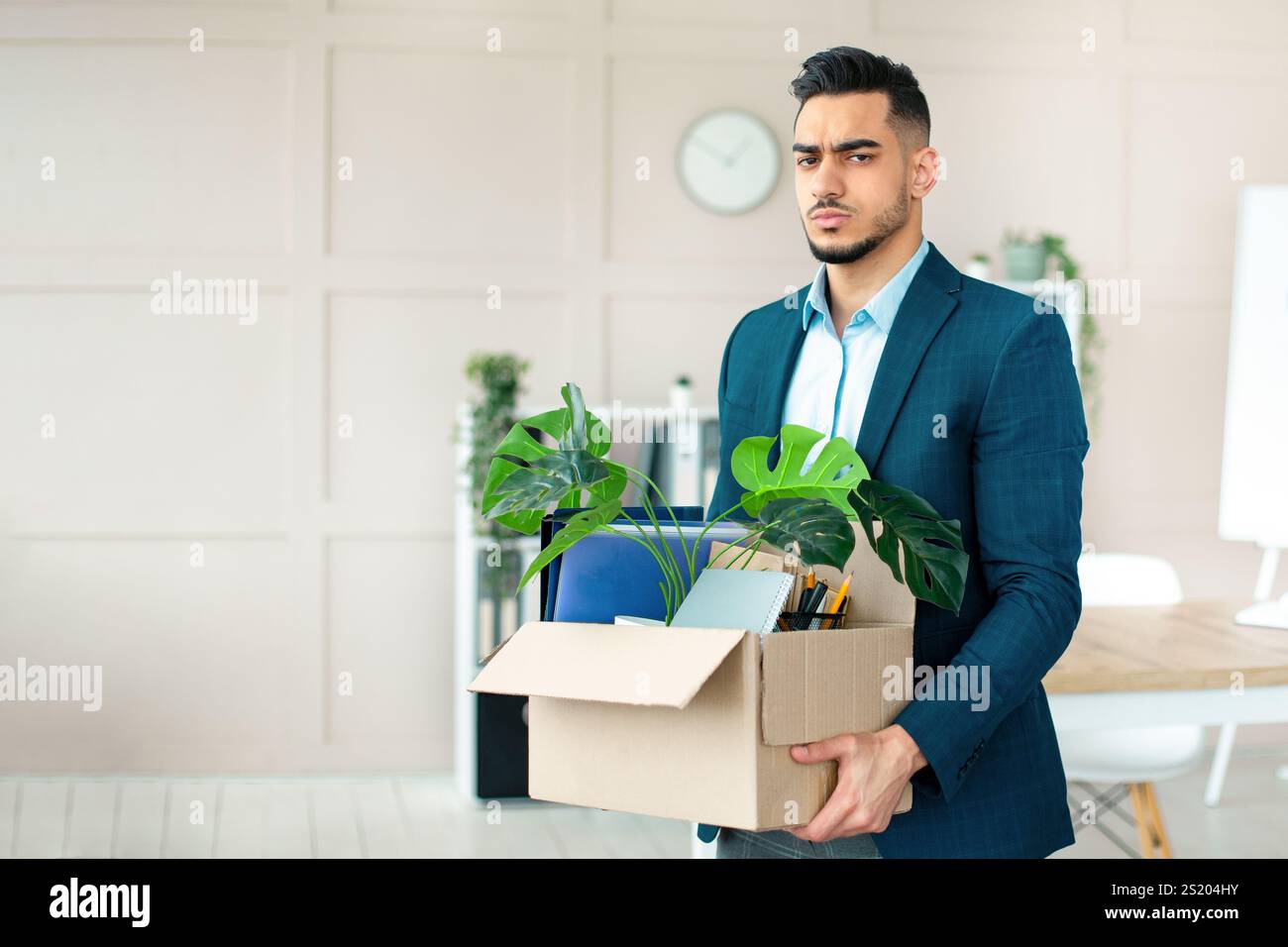 Concetto di crisi economica. Un uomo arabo infelice che detiene effetti personali dopo essere stato licenziato in carica Foto Stock