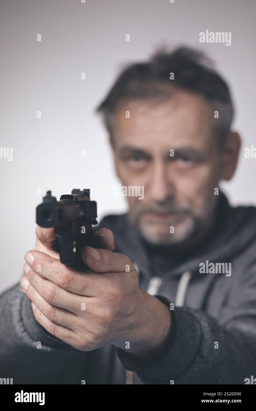 L'uomo si prende cura della pistola sportiva semi-automatica di piccolo calibro .22 LR Foto Stock