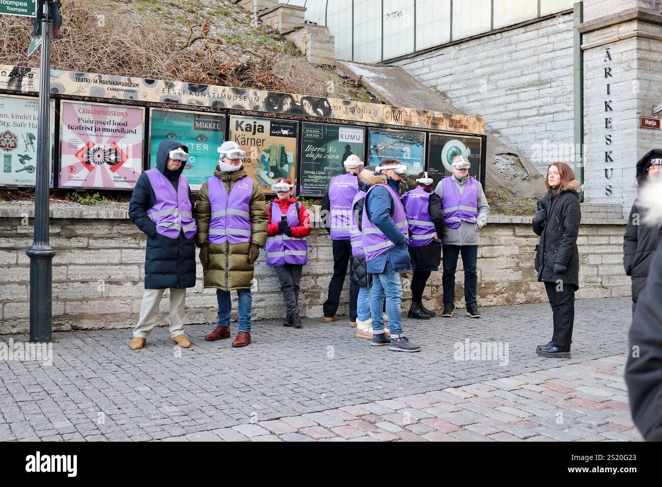 Turisti a Tallinn, Estonia, che esplorano la città storica con le cuffie ai, combinando la moderna tecnologia di viaggio con un fascino senza tempo in un tour coinvolgente Foto Stock