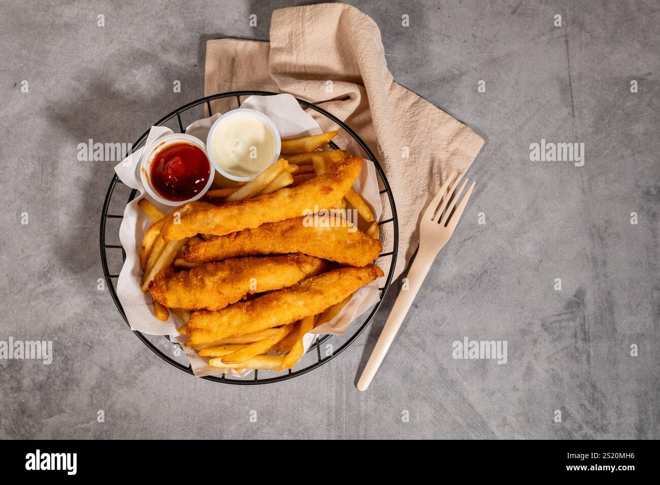 Pesce e patatine fritte con salsa di tater e ketchup nel cestello in filo metallico Foto Stock