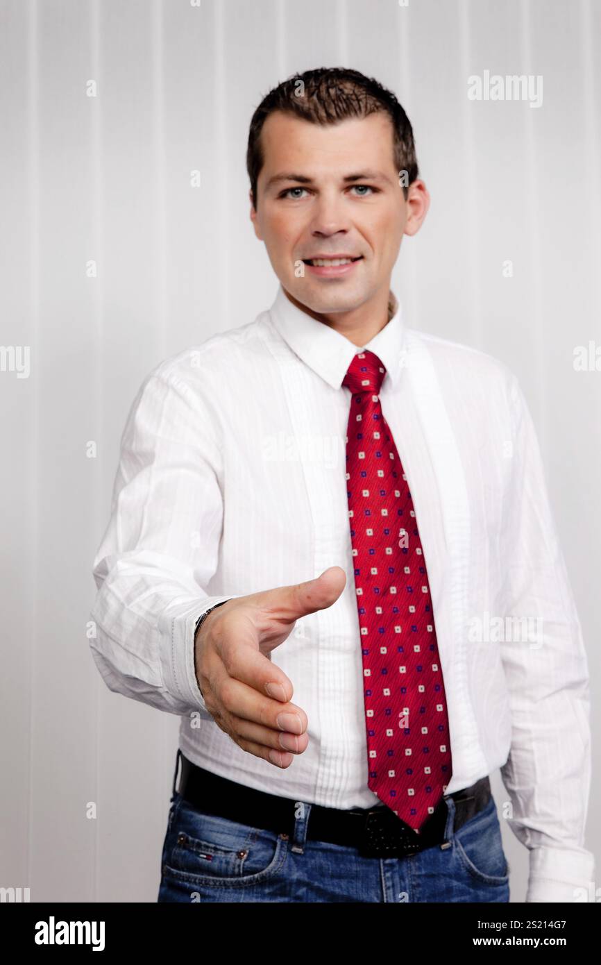 L'uomo d'affari si offre di stringere la mano. Transazione commerciale presso l'ufficio Austria Foto Stock