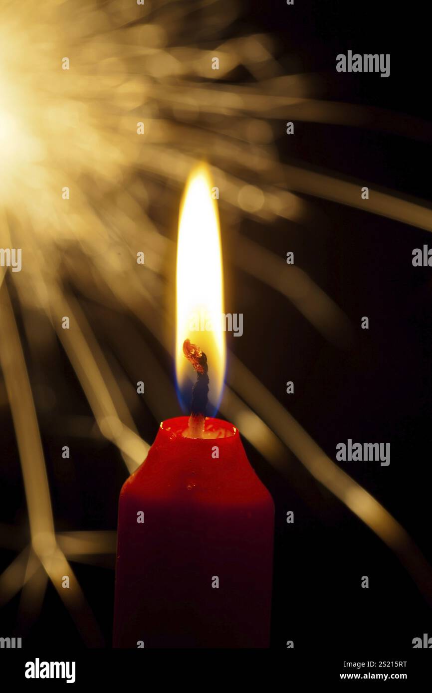 La fiamma di una candela porta la luce nell'oscurità. Con uno sparkler per Natale in Austria Foto Stock
