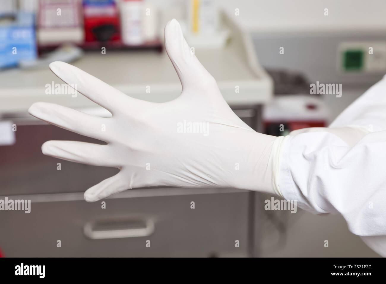 Un medico che indossa guanti in lattice. Protezione e sicurezza in laboratorio, Un medico che indossa guanti in lattice. Protezione e sicurezza in laboratorio. Foto Stock