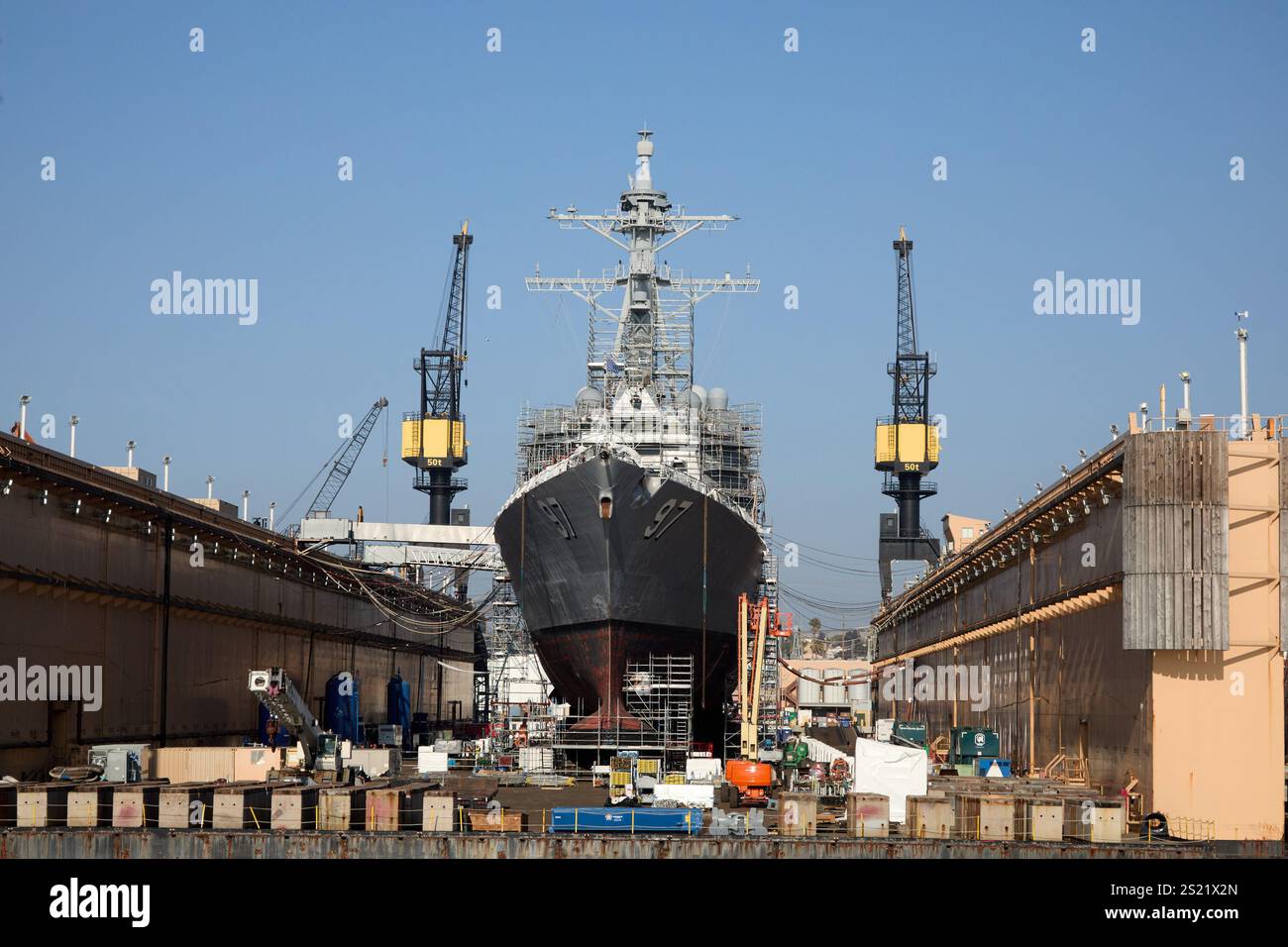San Diego, California, Stati Uniti. 21 dicembre 2024. La USS Halsey (DDG-97), un cacciatorpediniere missilistico guidato classe Arleigh Burke, in manutenzione in un bacino di carenaggio galleggiante. L'impalcatura circonda lo scafo della nave come parte del processo di riparazione e ricondizionamento. I carroponte sono pronti a fornire assistenza durante il sollevamento pesante richiesto durante questo lavoro minuzioso. L'infrastruttura del bacino di carenaggio mette in mostra le capacità avanzate dei cantieri navali nel sostenere la preparazione della flotta. (Credit Image: © Ian L. Sitren/ZUMA Press Wire) SOLO PER USO EDITORIALE! Non per USO commerciale! Foto Stock
