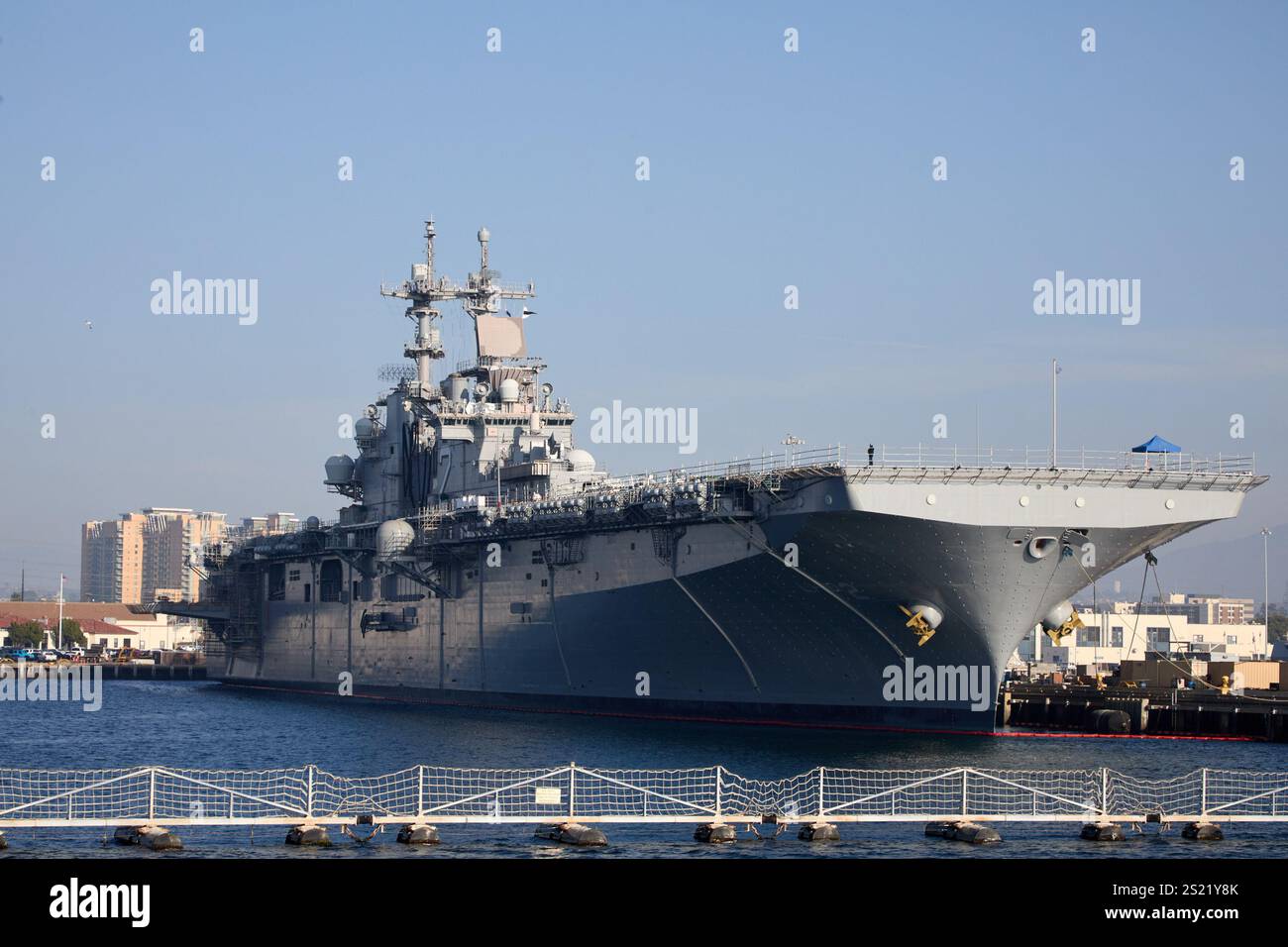 San Diego, California, Stati Uniti. 21 dicembre 2024. La USS Essex (LHD-2), una nave d'assalto anfibia classe Wasp della US Navy, attraccò nel suo porto di San Diego. Progettato per offrire versatilità, Essex supporta una vasta gamma di operazioni, tra cui il trasporto e l'impiego di marine, elicotteri e mezzi da atterraggio. La sua struttura imponente e il ponte ben attrezzato lo rendono un componente vitale delle capacità anfibie della Marina. Questa immagine cattura l'Essex come parte della vivace infrastruttura navale di San Diego, incorniciata dallo skyline della città e dallo sfondo montuoso. (Immagine di credito: © Ian L. Sitren/ZUMA Pres Foto Stock