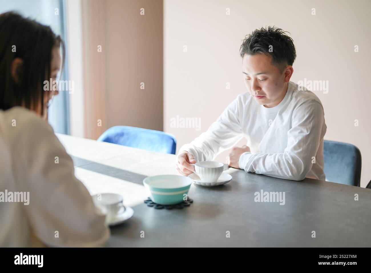 Una coppia giapponese, una donna di 30 anni e un uomo di 20 anni, si godono il tè pomeridiano a casa. Foto Stock